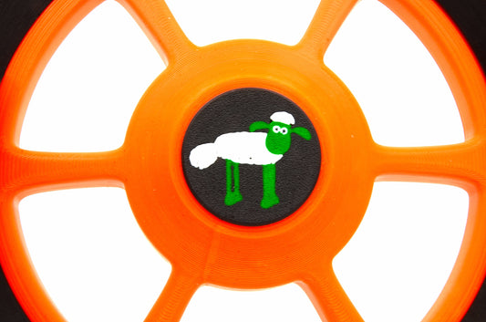 2 zwarte schaapsbadges op de achtergrond voor aangepaste Husqvarna Automower-wielen met een diameter van 210 en 250 mm